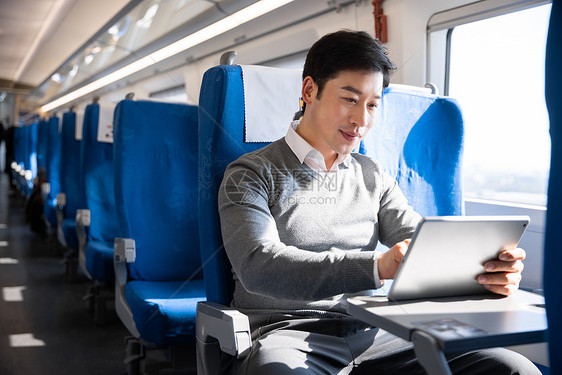 男性在列车上使用平板电脑图片