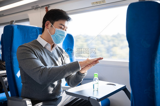 在列车上使用消毒酒精的男性图片