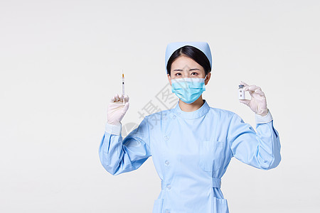 戴口罩的护士手拿注射器和新冠疫苗图片