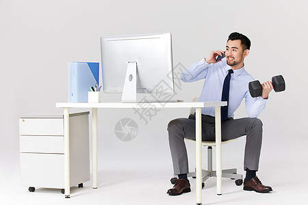 职场男士在办公室健身举哑铃图片