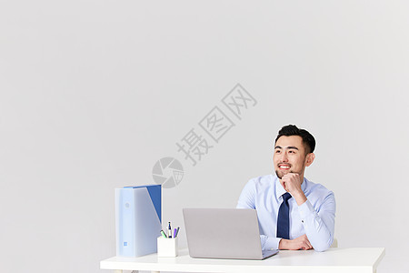 在办公桌前思考的职场男性图片