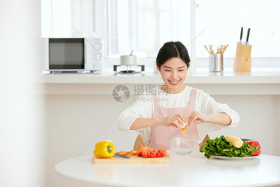 年轻女性厨房打蛋做早餐图片