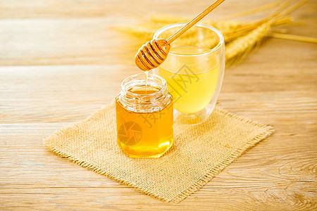 喝蜂蜜水木桌上的蜂蜜和蜂蜜水背景