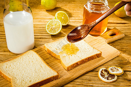 木桌上的面包蜂蜜牛奶图片