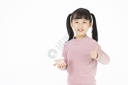 手拿牙齿模型的小女孩点赞图片