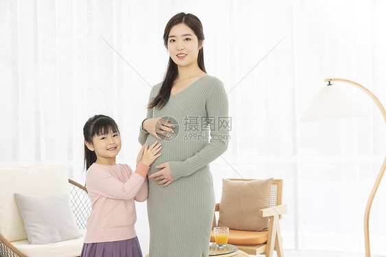 小女孩抚摸妈妈的孕肚图片