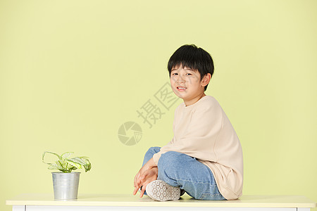 地球上的绿植坐在桌子上的小男孩背景
