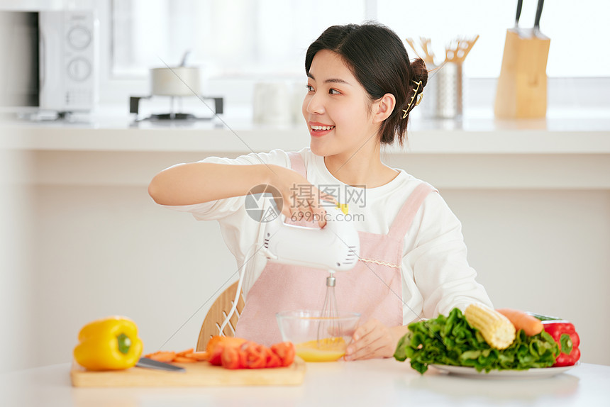 年轻女性厨房使用打蛋机打蛋图片