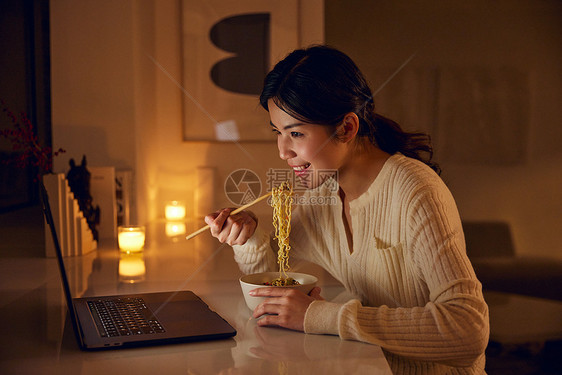 居家女性熬夜看剧吃泡面图片