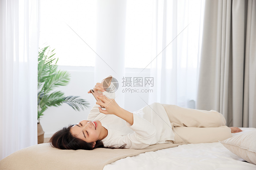 年轻女性周末宅女生活玩手机图片