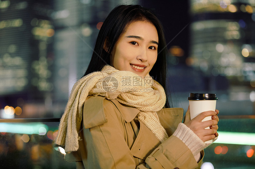 冬季夜晚都市女性人像手握咖啡杯图片