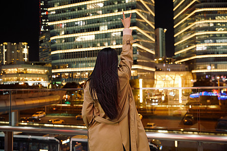 手机励志冬季夜晚都市女性人像举手欢呼背景