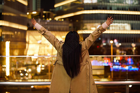 女性励志冬季夜晚都市女性人像双手举起欢呼背景