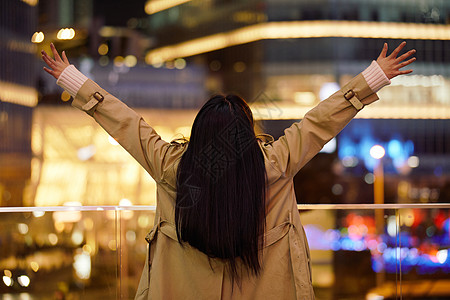 手机励志冬季夜晚都市女性人像双手举起欢呼背景