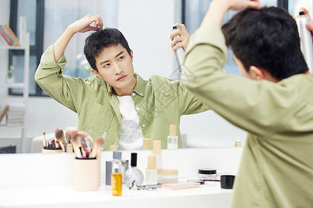 年轻男士镜子前整理发型图片