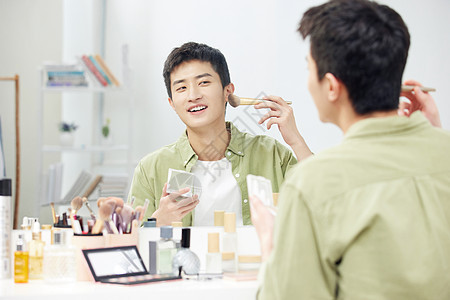年轻男士镜子前化妆背景图片
