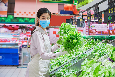 佩戴口罩的超市服务员整理蔬菜区图片