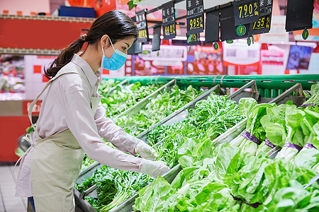 佩戴口罩的超市服务员整理蔬菜区图片