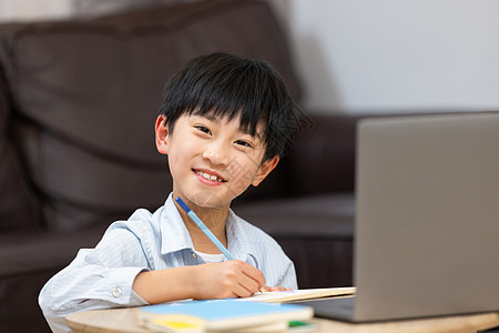小男孩在家使用笔记本电脑上网课图片