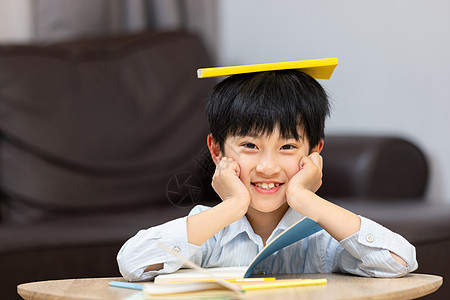 小男孩把书放在头顶图片