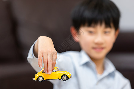 小男孩手拿着一辆玩具车图片