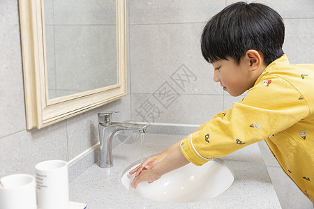 穿着睡衣的小男孩在浴室洗手图片