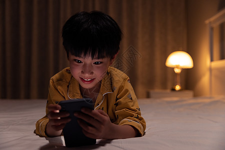 小男孩在黑暗中玩手机图片