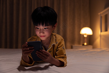 小男孩在黑暗中使用手机图片
