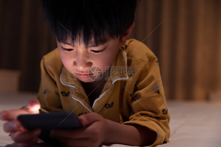 在黑夜里看手机表情难过的小男孩图片