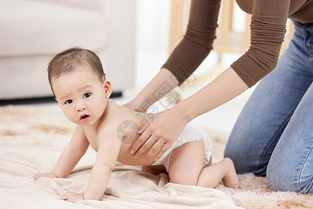女性的手仔细给婴儿擦拭身体乳图片