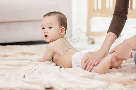 女性的手在仔细给婴儿擦拭身体乳高清图片