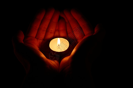祈福祝福手捧着燃烧的蜡烛背景图片