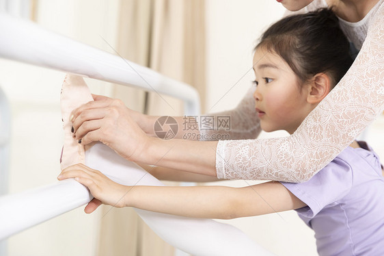 舞蹈老师帮助小女孩压腿图片