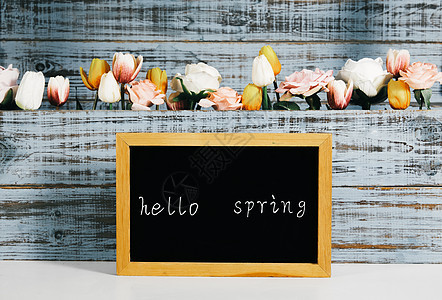 黑板上写着hello spring 和满是鲜花背景板背景图片