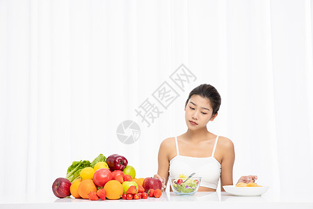 厌倦吃水果沙拉的年轻女孩图片