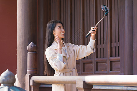 美女大学生春游拿自拍杆拍照背景