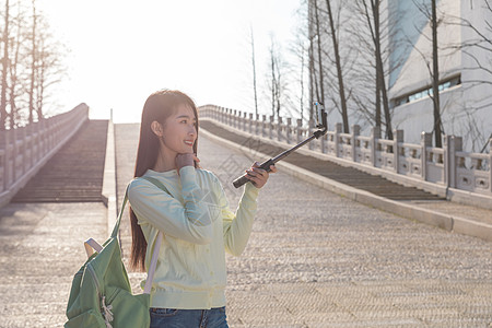 美女大学生春游拿自拍杆拍照图片