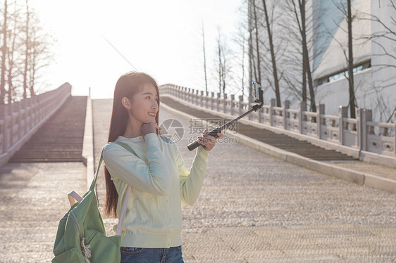 美女大学生春游拿自拍杆拍照图片