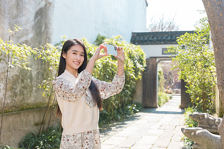 美女大学生旅行用手机拍照图片