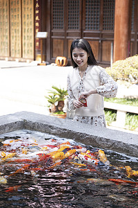 美女大学生逛寺庙喂食金鱼图片