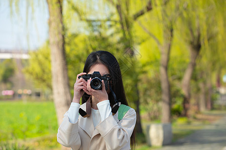 青春美女大学生背着相机旅行拍照背景图片