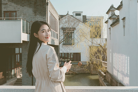 青春美女大学生背着相机旅行拍照背景图片