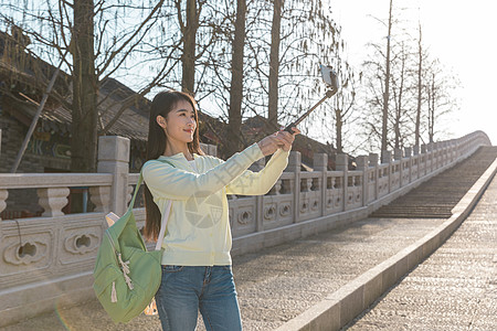 美女大学生春游拿自拍杆拍照图片