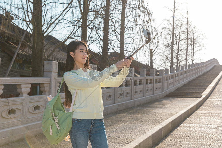 美女大学生春游拿自拍杆拍照图片