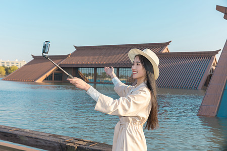 美女大学生春游拿自拍杆拍照背景