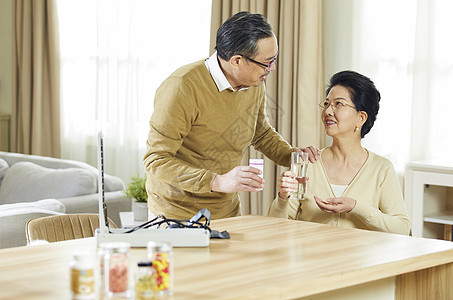 中老年夫妇居家陪伴吃药背景图片