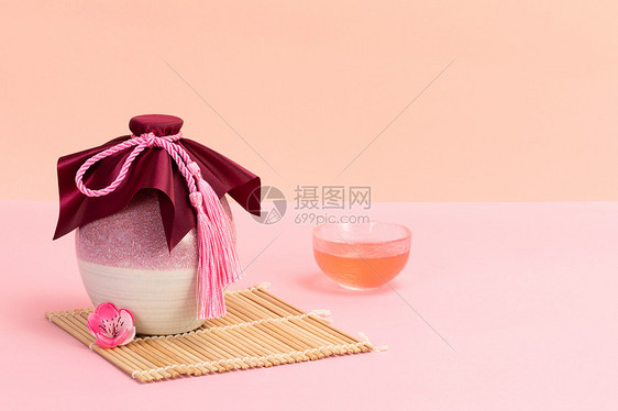粉色背景静物酒坛子和酒杯桃花酒图片