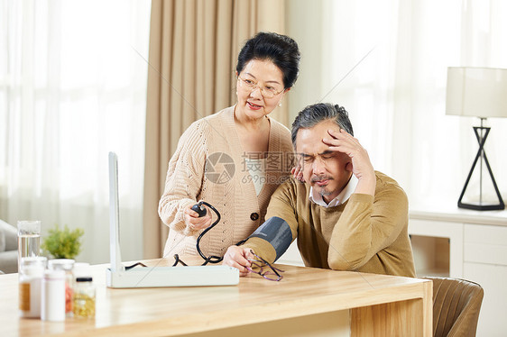 中老年女士给高血压丈夫测量血压图片