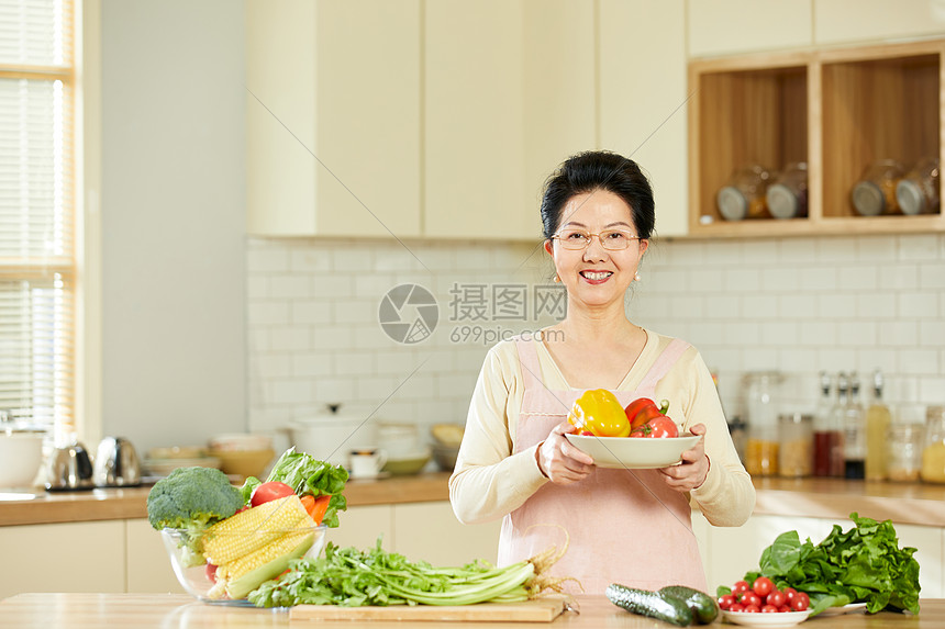 中老年女性手捧新鲜蔬菜图片