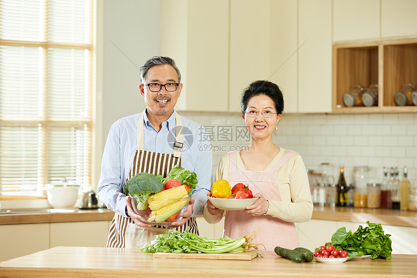 中老年夫妇手捧新鲜蔬菜图片